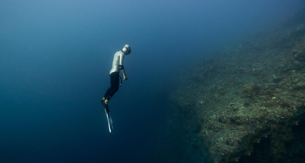 A scuba diver explores the depths of a coral reef in Bali, capturing the underwater beauty.